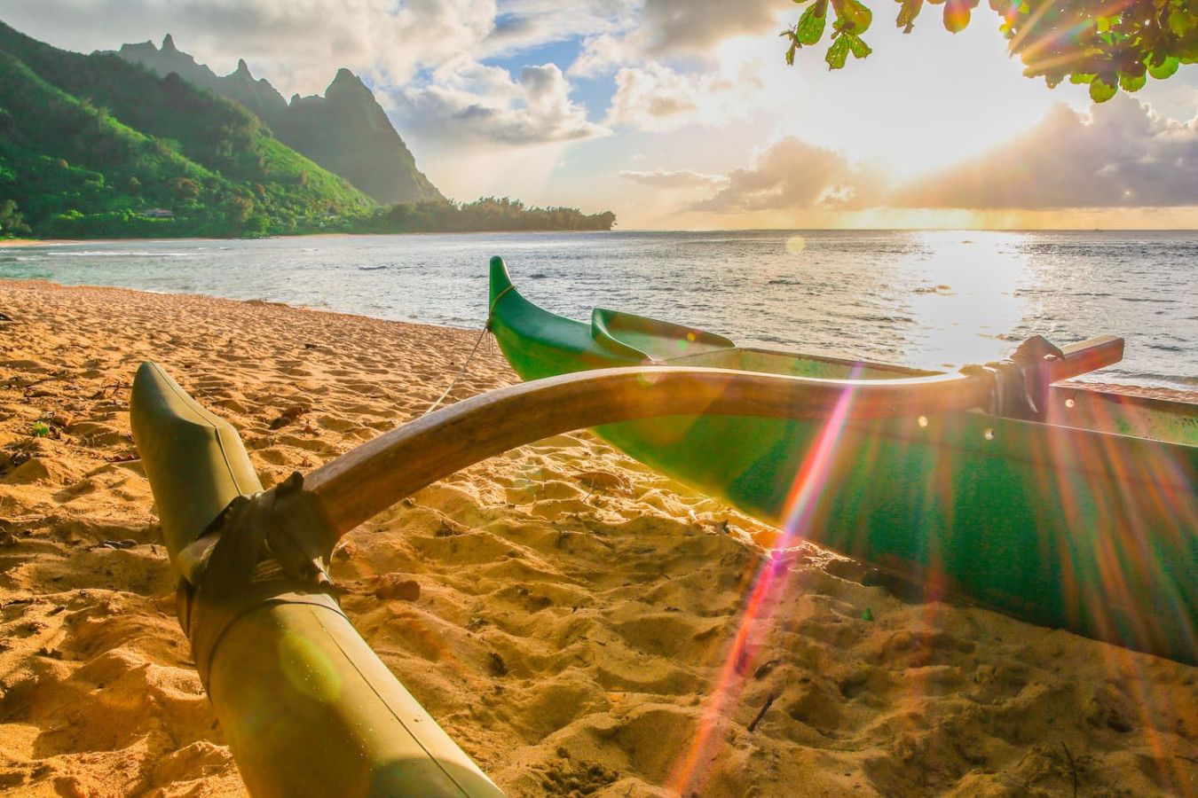 A beach with a boat and mountains in the background.