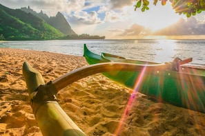 Una playa con un bote y montañas al fondo.