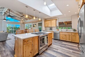 Une cuisine moderne avec des meubles en bois, un îlot central et une lucarne.