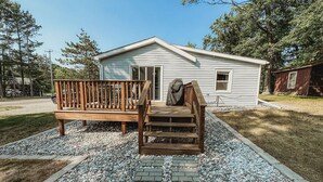 A single-story house with a front deck and a covered outdoor area. - The Bungalow on Lake Drive (Shawano)