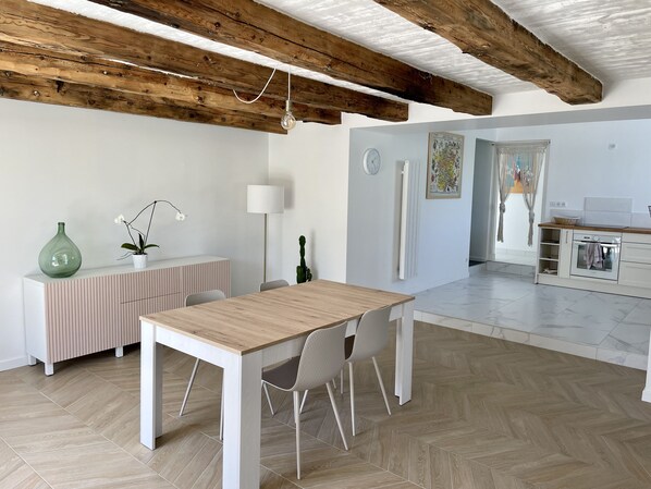 Une cuisine moderne avec des armoires blanches, un plan de travail en bois et un four encastré.
