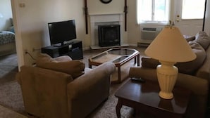 Un salon équipé d’un téléviseur, d’une cheminée et de sièges confortables.