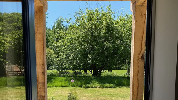 Una puerta que da a un patio de piedra con una pérgola de madera.