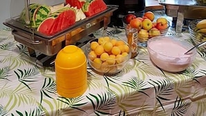 A buffet table with various fruits and a juice dispenser. - Wichernhaus-Boltenhagen (Boltenhagen)