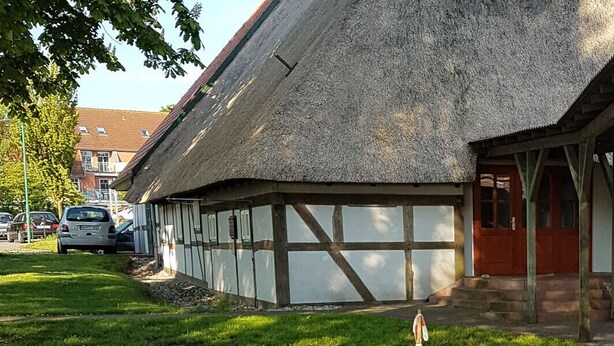 A traditional half-timbered building with a thatched roof and a wooden porch. - Wichernhaus-Boltenhagen (Boltenhagen)