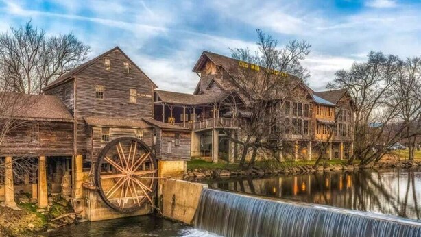 A historic water mill with wooden buildings and a large water wheel. - *Cozy 2BR + LOFT! • Game Room • HOT TUB! • Arcade* (Sevierville)
