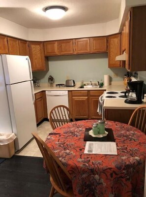 Enjoy meals in the kitchen with a dining table and chairs, a dishwasher, and a stove with four burners.