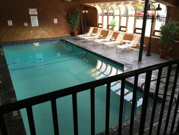 Relax by the rectangular pool surrounded by lounge chairs and lush greenery.