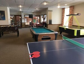 Relax and unwind in this spacious room, featuring a pool table, ping pong table, and billiards table for endless entertainment.