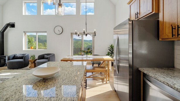 A modern kitchen with a large island, stainless steel appliances, and a view of the outdoors. - Alpine Escape: Family-Friendly Cabin with Spectacular Views (Divide)