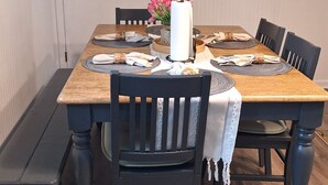 Une table à manger avec des sets de table, un vase de fleurs et des chaises.