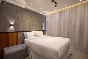 Ein modernes Schlafzimmer mit einem großen Bett, einer Bank und einer strukturierten Wand.