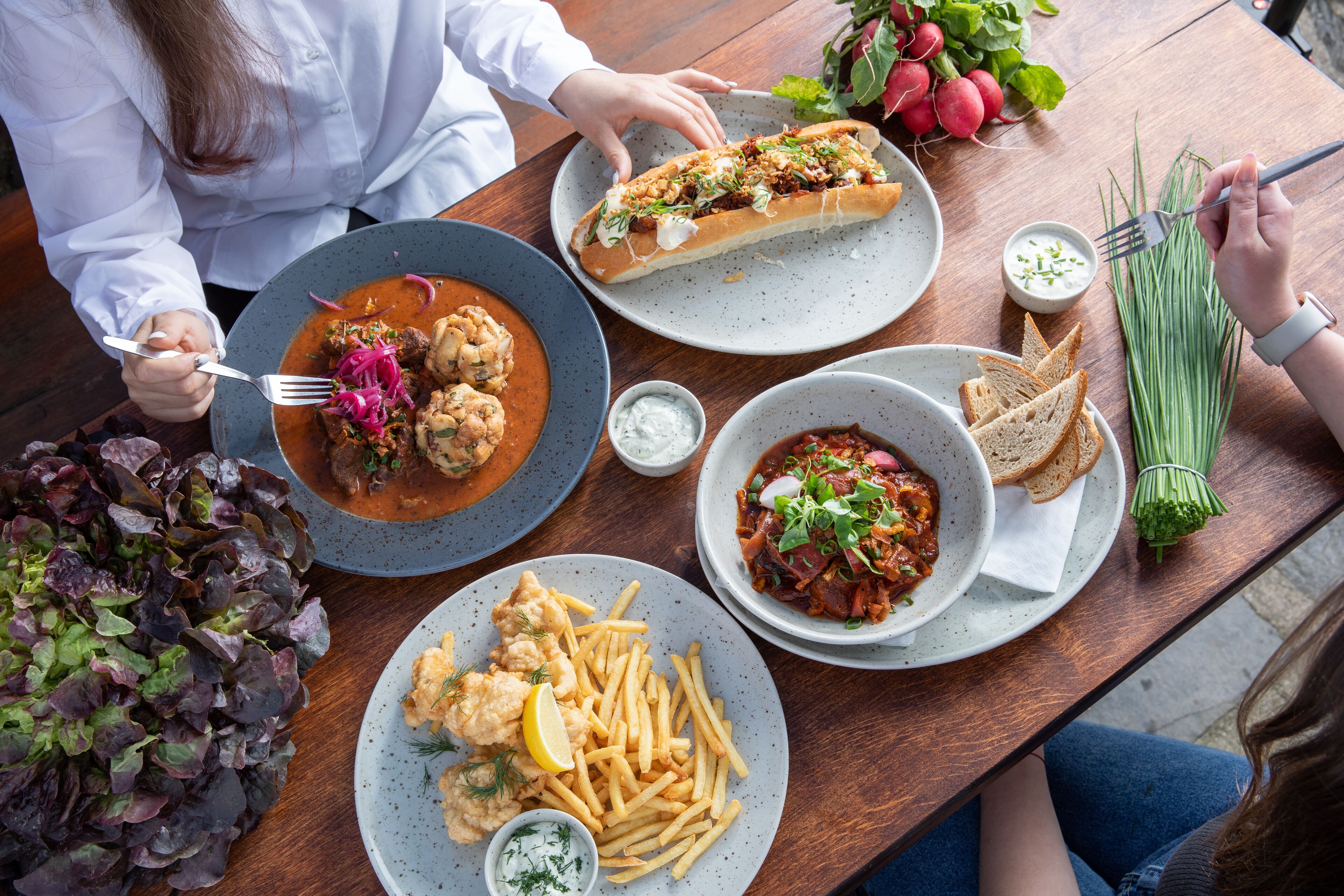 Une table à manger avec divers plats, notamment des fruits de mer, du pain et des légumes.