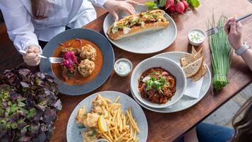 Une table à manger avec divers plats, notamment des fruits de mer, du pain et des légumes.