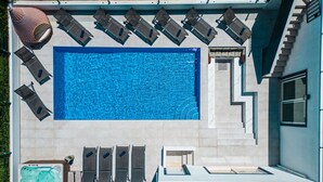 A rooftop pool with a rectangular shape, surrounded by lounge chairs and a hot tub. - Spacious Villa: Jacuzzi, Cinema & Heatable Pool (Pêra)