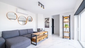 A modern living room with a grey sectional sofa, a wooden coffee table with drawers, and three round mirrors on the wall. - Spacious Villa: Jacuzzi, Cinema & Heatable Pool (Pêra)