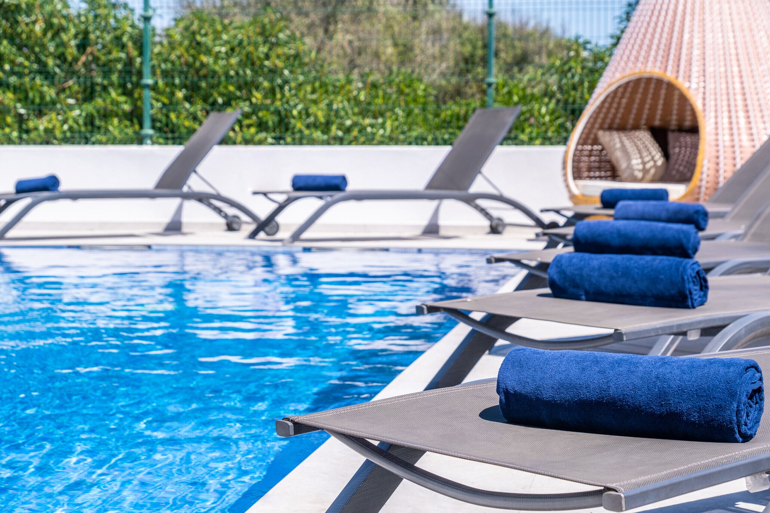 Un espace aménagé au bord de la piscine, avec des chaises longues et des serviettes.