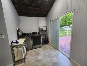 Enjoy cooking in this well-equipped kitchen with a stove, dishwasher, and sink, offering a view of the outdoor area.