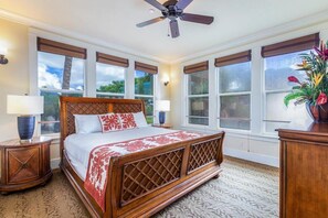 A spacious bedroom with a large bed, wooden headboard, and a ceiling fan. - 3BR I Luxury Villa l Designer Furnishings, Central A/C (Koloa)