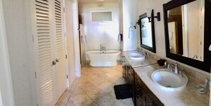 A bathroom with a bathtub, two sinks, and a large mirror. - 3BR I Luxury Villa l Designer Furnishings, Central A/C (Koloa)