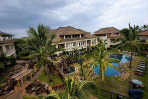 A resort with multiple buildings, a swimming pool, and a waterfall feature.