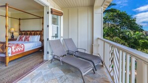 Un balcon doté d’un lit à baldaquin et de deux fauteuils.