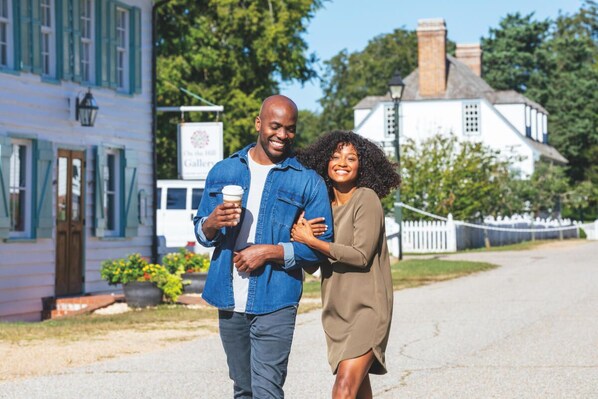 Un couple se promène dans une rue, devant un immeuble sur lequel on peut lire l’inscription « The Gallery ».
