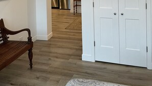 A modern kitchen with stainless steel appliances, a wooden bench, and a white door. - 15 minutes to EAA. Newly renovated, Luxury 1 Bedroom in historic downtown Neenah (Neenah)