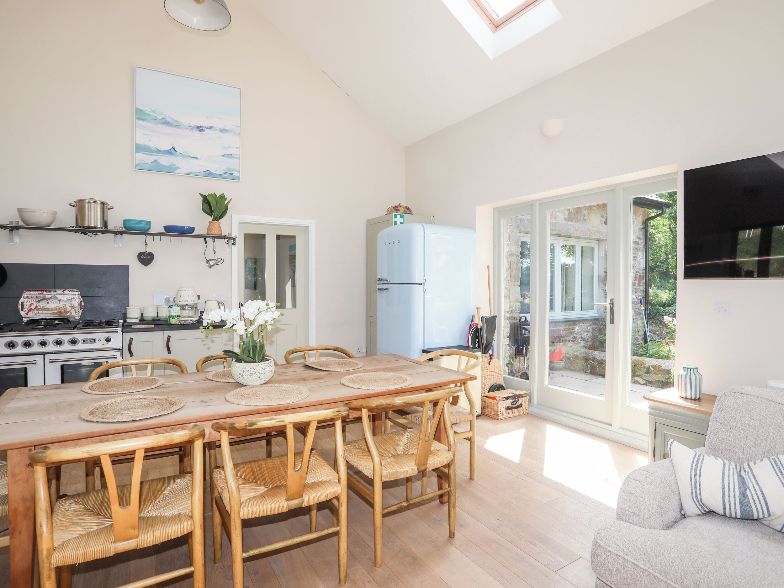 A spacious kitchen with a dining area, a large window, and a cozy seating area.