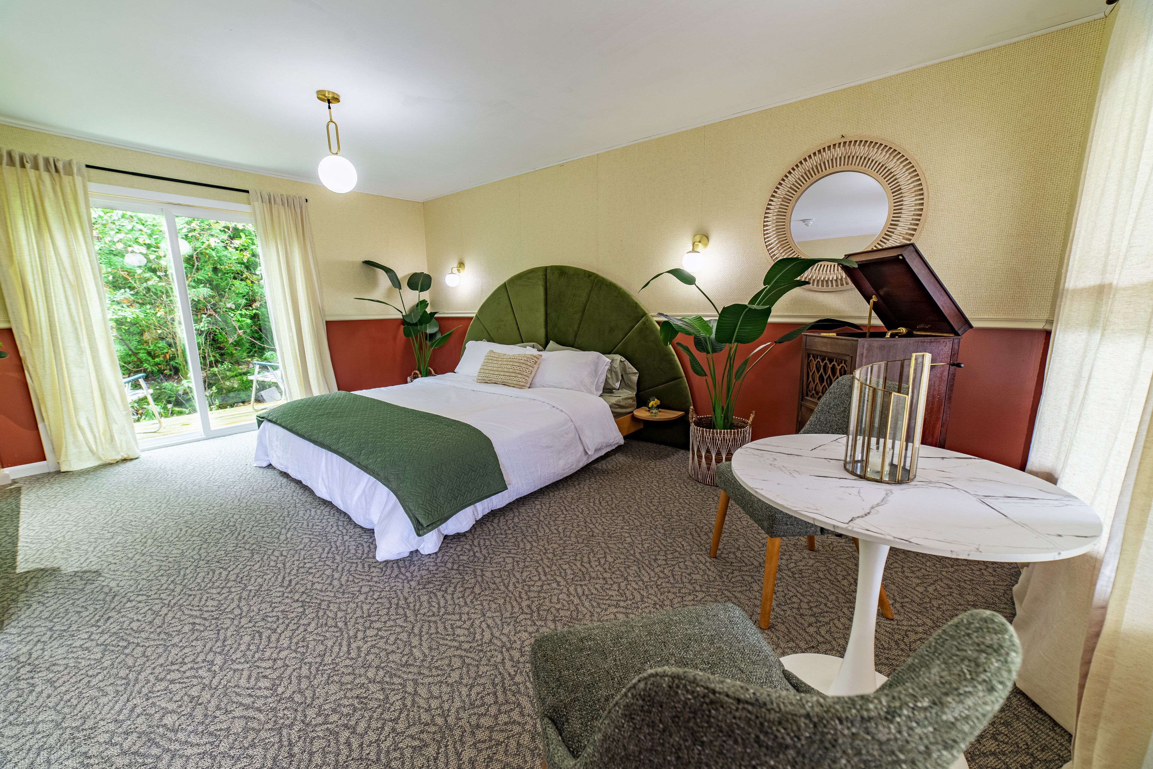 A hotel room with a bed, a round table, and a chair.