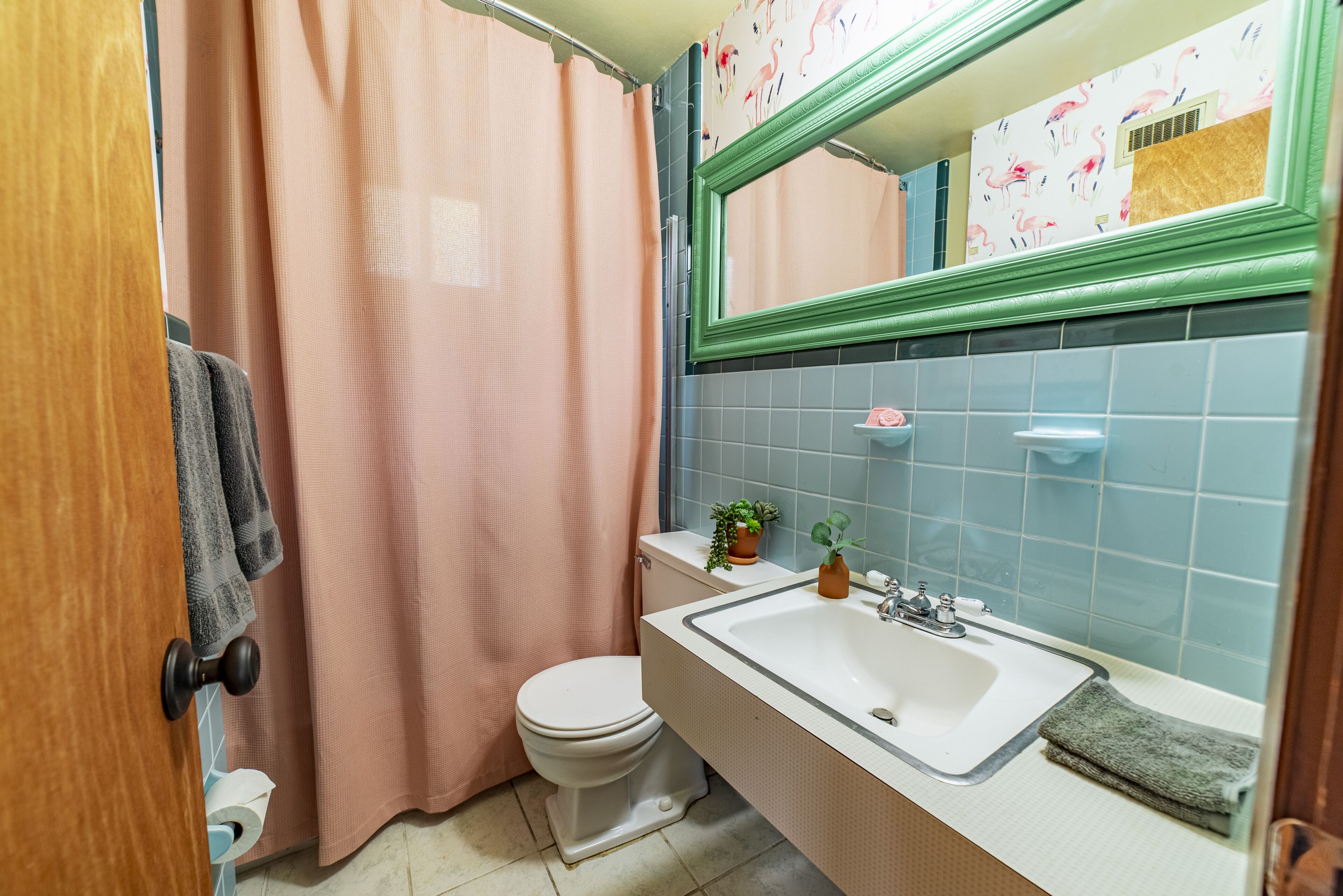 A bathroom with a toilet, sink, and shower curtain.