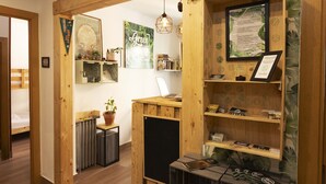 A wooden interior with a laptop on a desk, a framed certificate, and shelves with items. - Green Hostel (Oviedo)