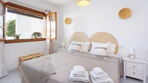A bedroom with a bed, bedside tables, a window with blinds, and a hanging light fixture. - Home2Book Stylish Apt Pool & Terrace, Sand Club (Oasis del Sur)