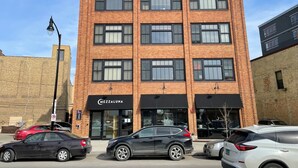 A multi-story brick building with a storefront labeled "Mezzaluna."