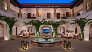 A courtyard with a central fountain, seating areas, and a television screen. - Zoëtry Casa del Mar intimate, oceanfront luxury and golf (San José del Cabo)