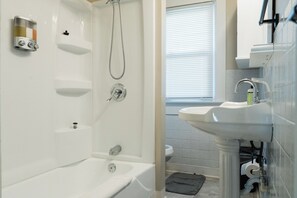 A modern bathroom with a bathtub, shower, and sink. - Quaint, Cozy, Updated Home -- 15 min to US Air Force Museum! (Dayton)
