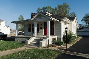 A single-story house with a front porch, a chimney, and a small garden area. - Quaint, Cozy, Updated Home -- 15 min to US Air Force Museum! (Dayton)