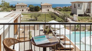 Un balcón con sillones de mimbre, una mesa con la carta y una zona de piscina.