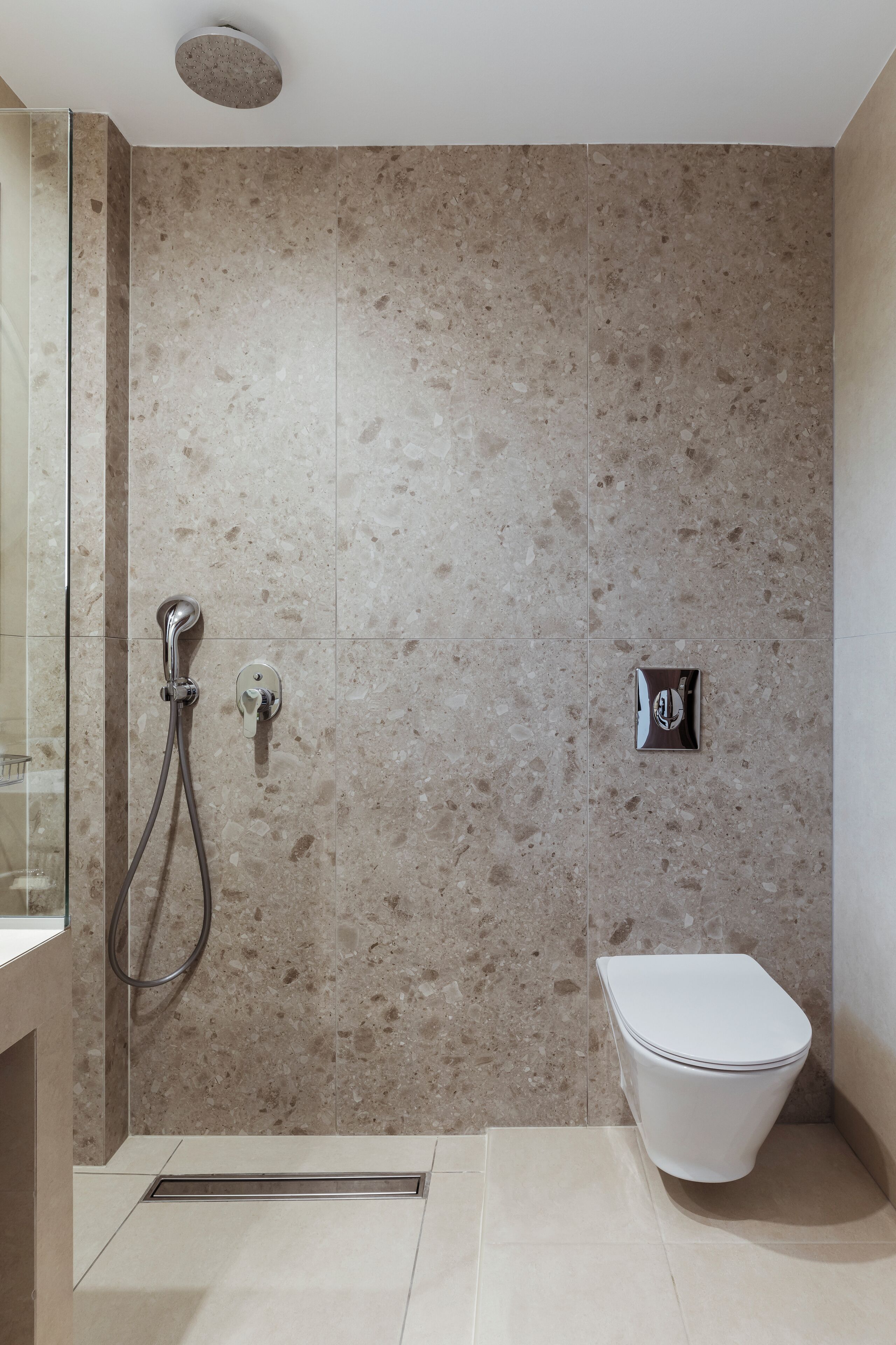 A modern bathroom with a shower, toilet, and a glass-enclosed shower area.