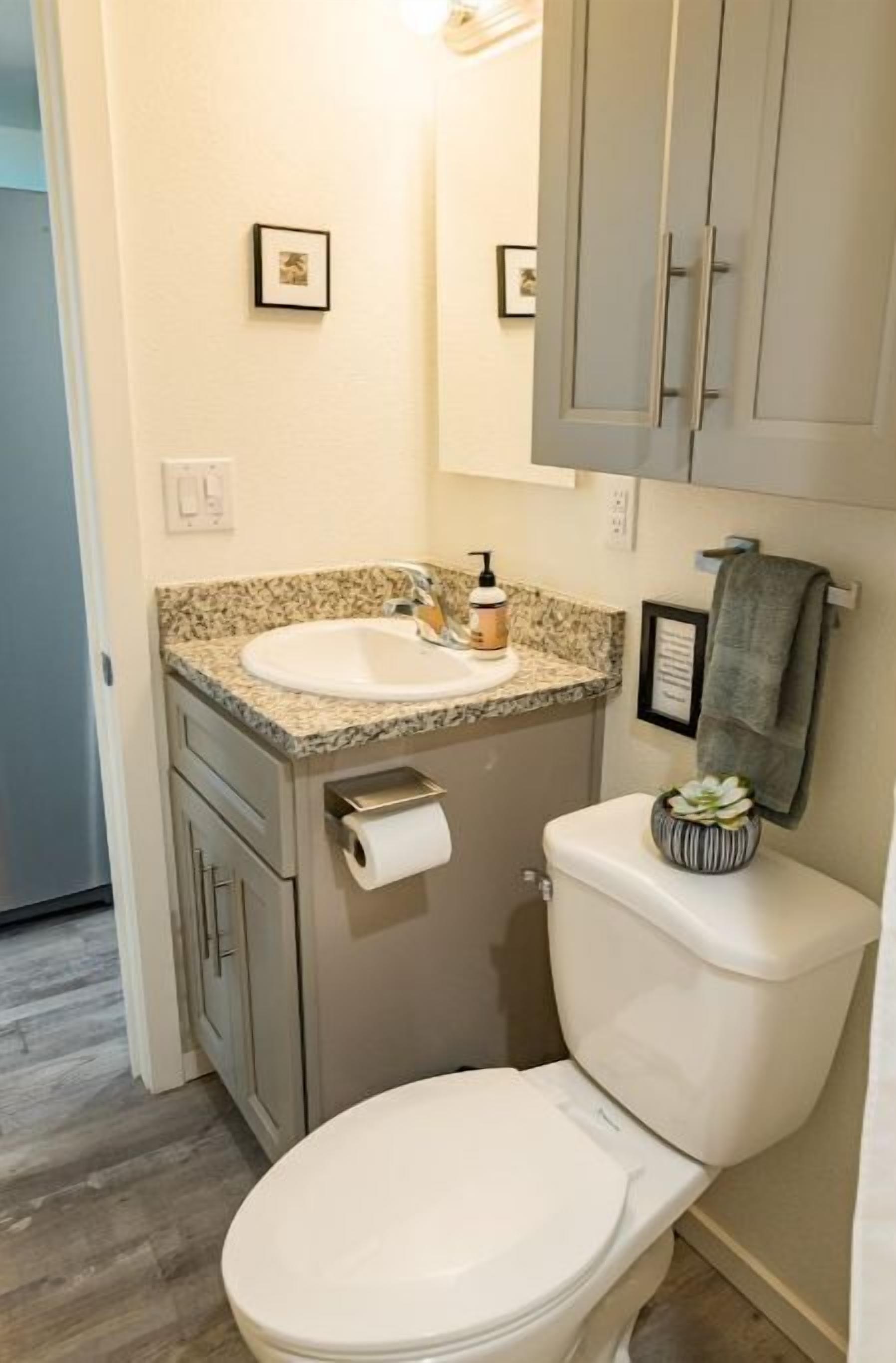 Une salle de bain avec des toilettes, un lavabo et un meuble de rangement.