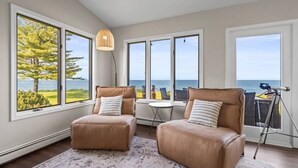 A room with two leather armchairs facing a large window with a view of the sea. - Sheridan Shores Escape - Hot Tub w Amazing Views! (Lexington Township)