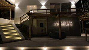 Een modern huis met een trap die leidt naar een overdekt buitengebied.