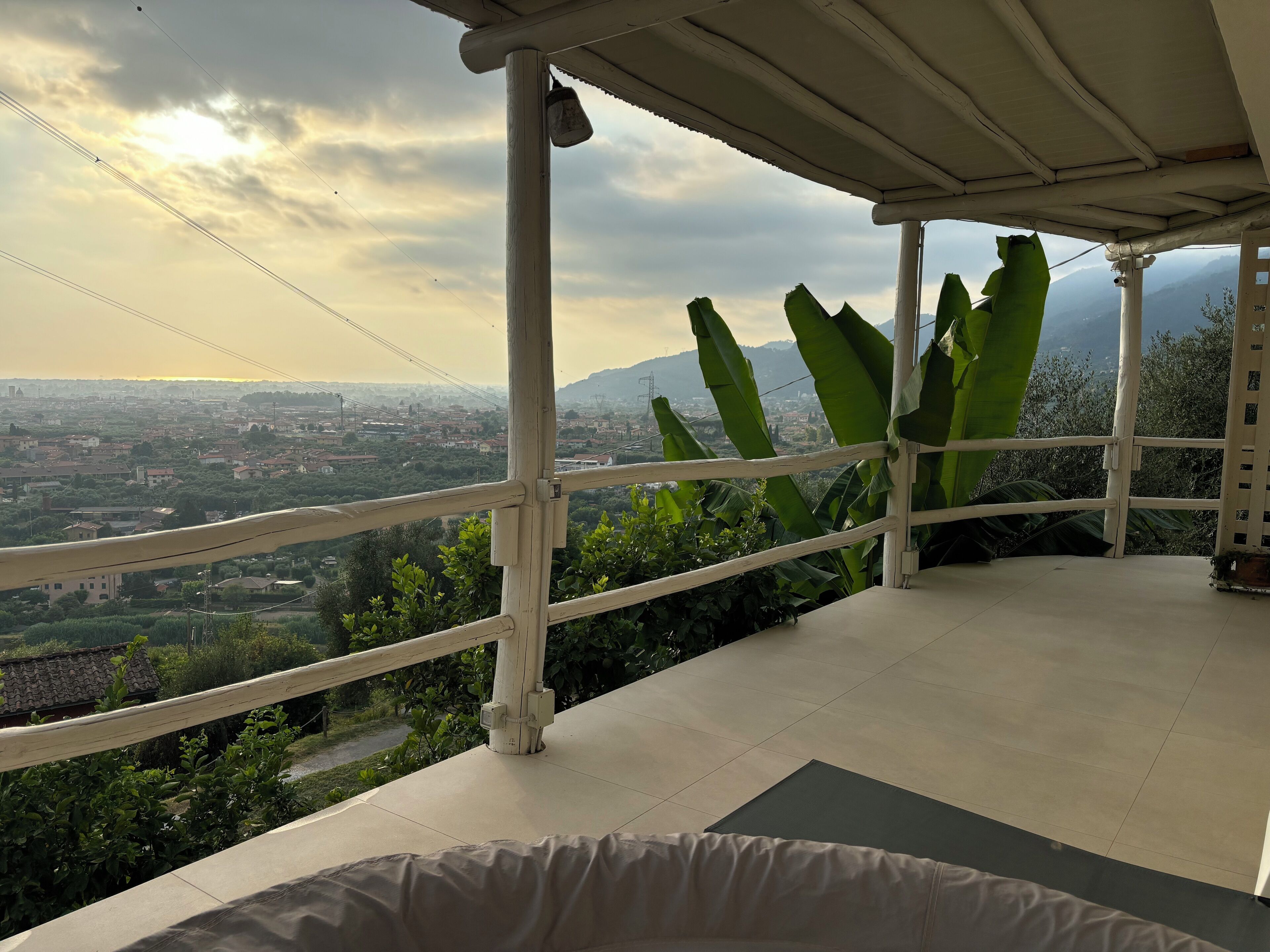 Un balcón con vistas a la ciudad y montañas.