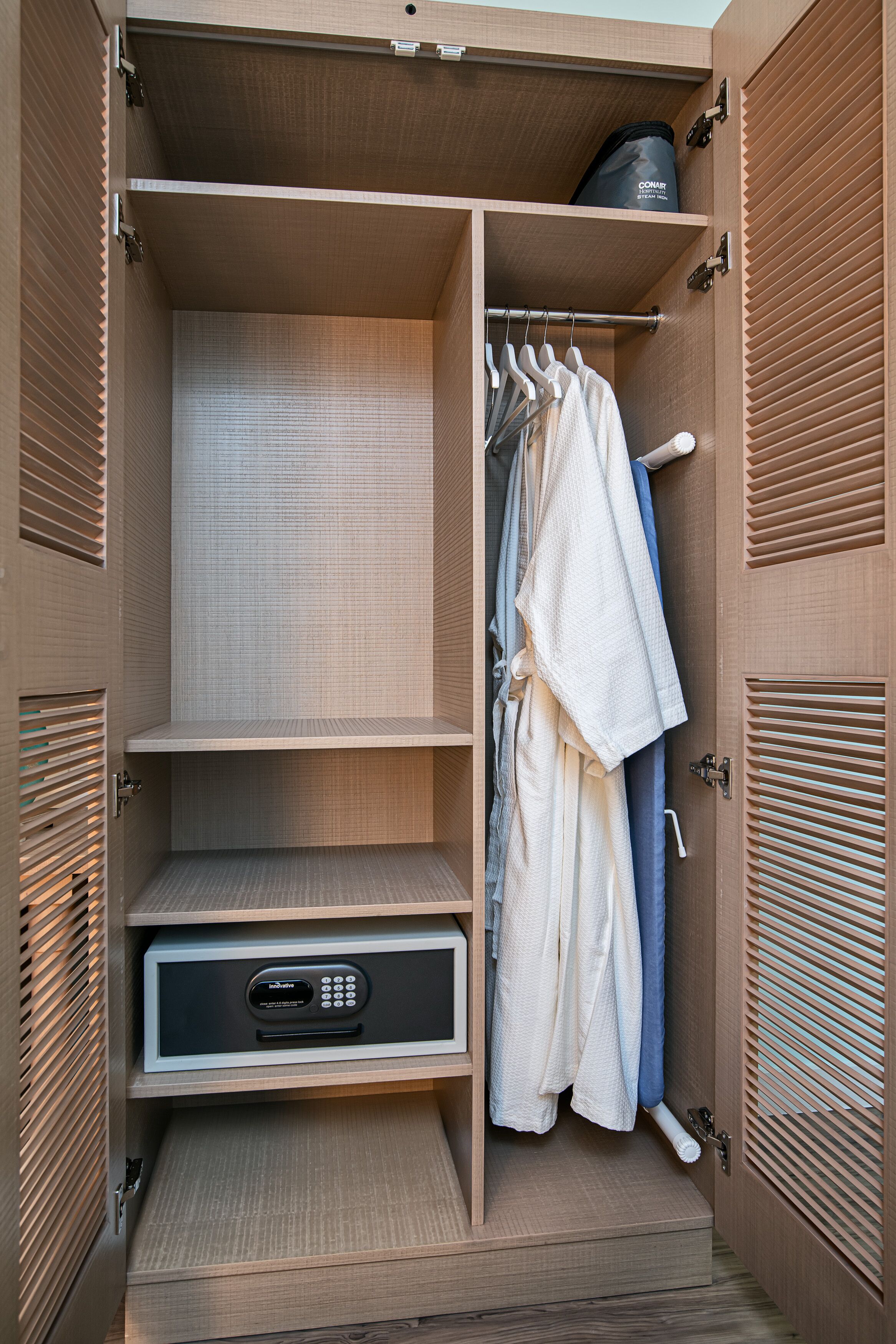 A walk-in closet with shelves, a hanging rack, and a storage unit.