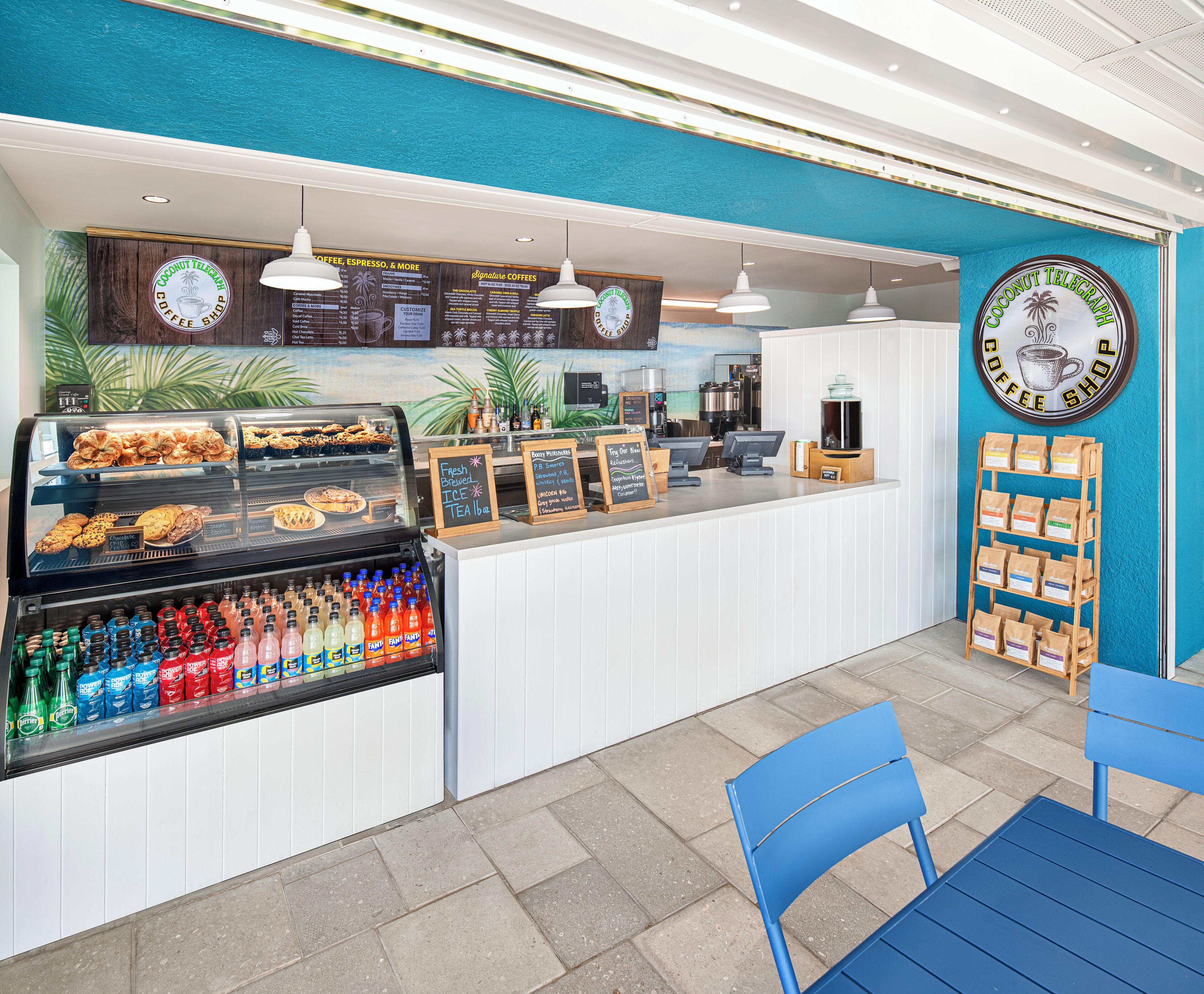 A coffee shop counter with a menu, a display case with pastries, and a coffee machine.