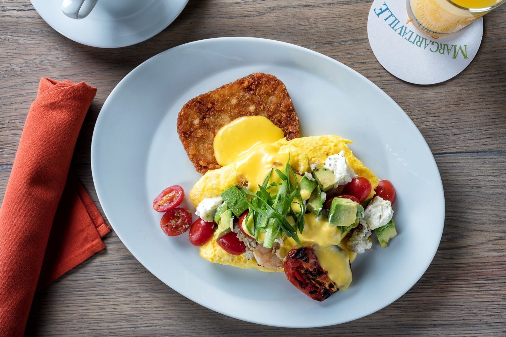 A plate of breakfast with eggs, avocado, and cherry tomatoes.