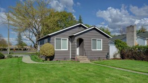 A single-story house with a front porch, a small front yard, and a well-maintained lawn. - Renovated Home in Central Point (Central Point)