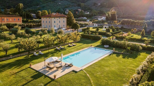 A pool area with lounge chairs, a pergola, and a view of surrounding hills. - Villa Annabelle - Six Bedroom Villa, Sleeps 18 (Lucca)