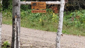 A rustic wooden sign with the text "Birch Haven Wayne & Deb" attached to a tree. - BIRCH HAVEN (Bancroft)