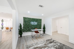 Una habitación moderna con una pared verde, una mesa y una silla.